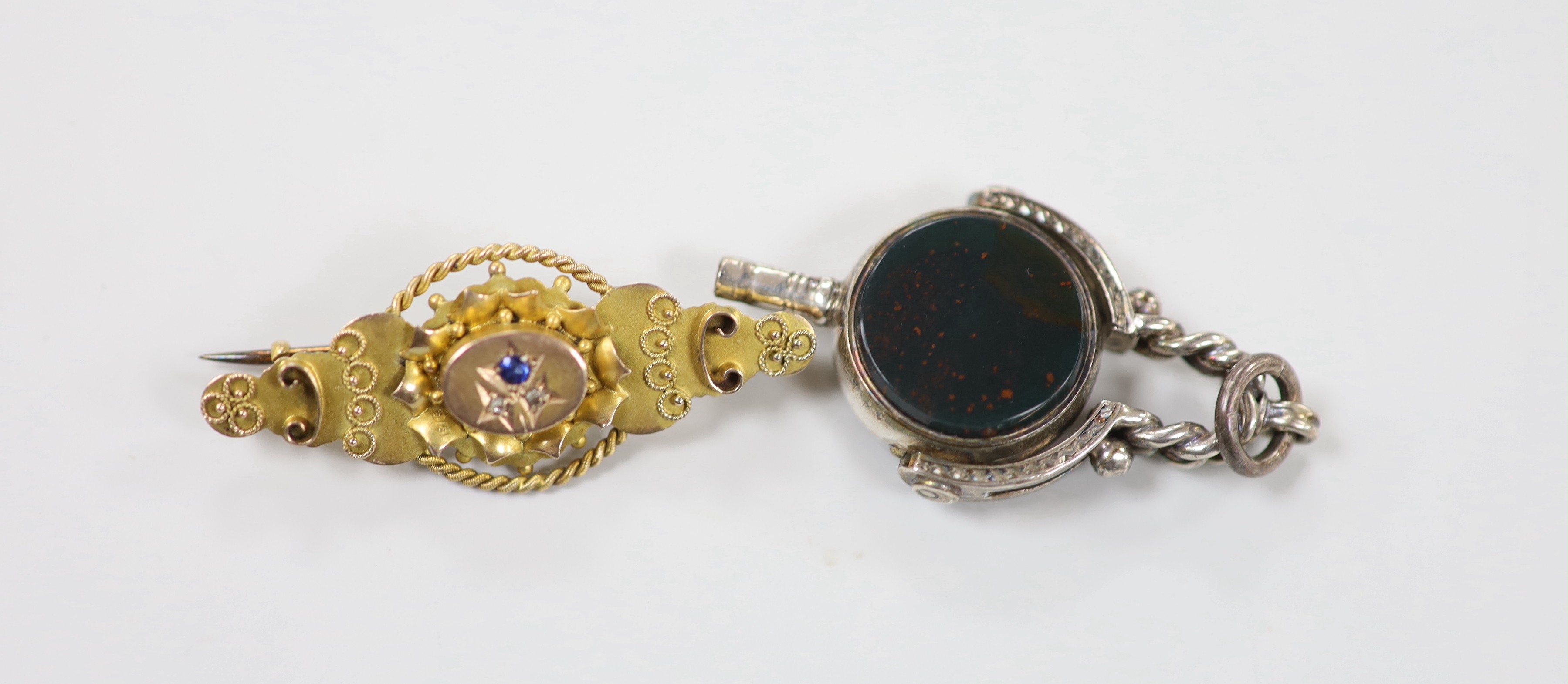 An Edwardian 9ct gold, sapphire and diamond chip set three stone brooch, 41mm, gross weight 33 grams and a bloodstone and carnelian set white metal spinning fob watch key.